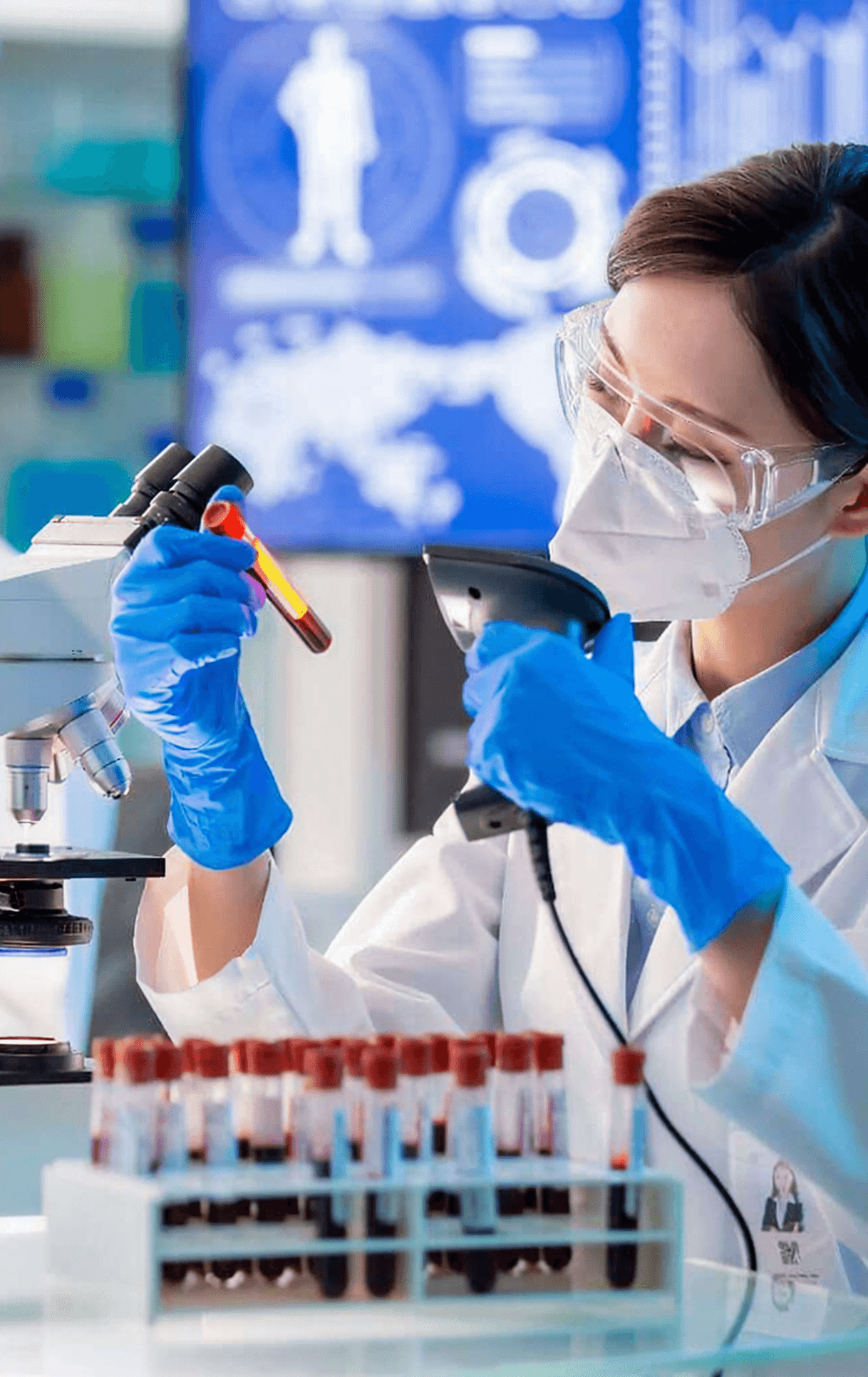A lab technician adding solution to a test tube