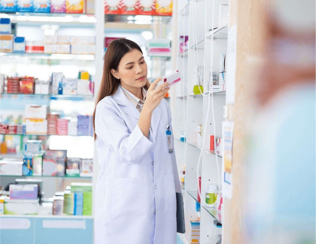 A woman in a labcoat inspecting a box of prescription medication